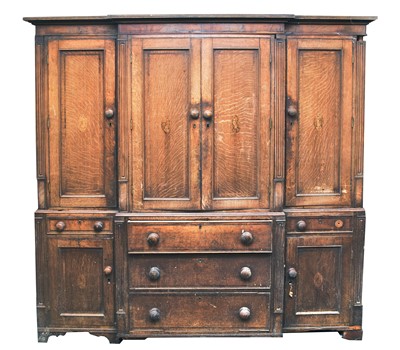 Lot 820 - An early-mid 19th century oak breakfront housekeeper's cupboard