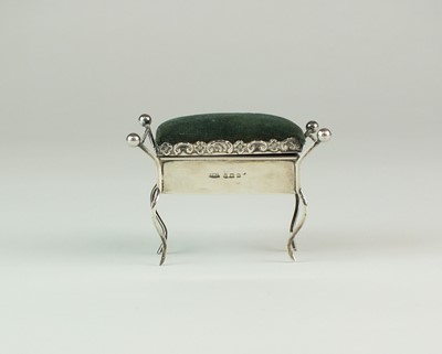 Lot 24 - An Edwardian novelty silver pin cushion in the form of a piano stool