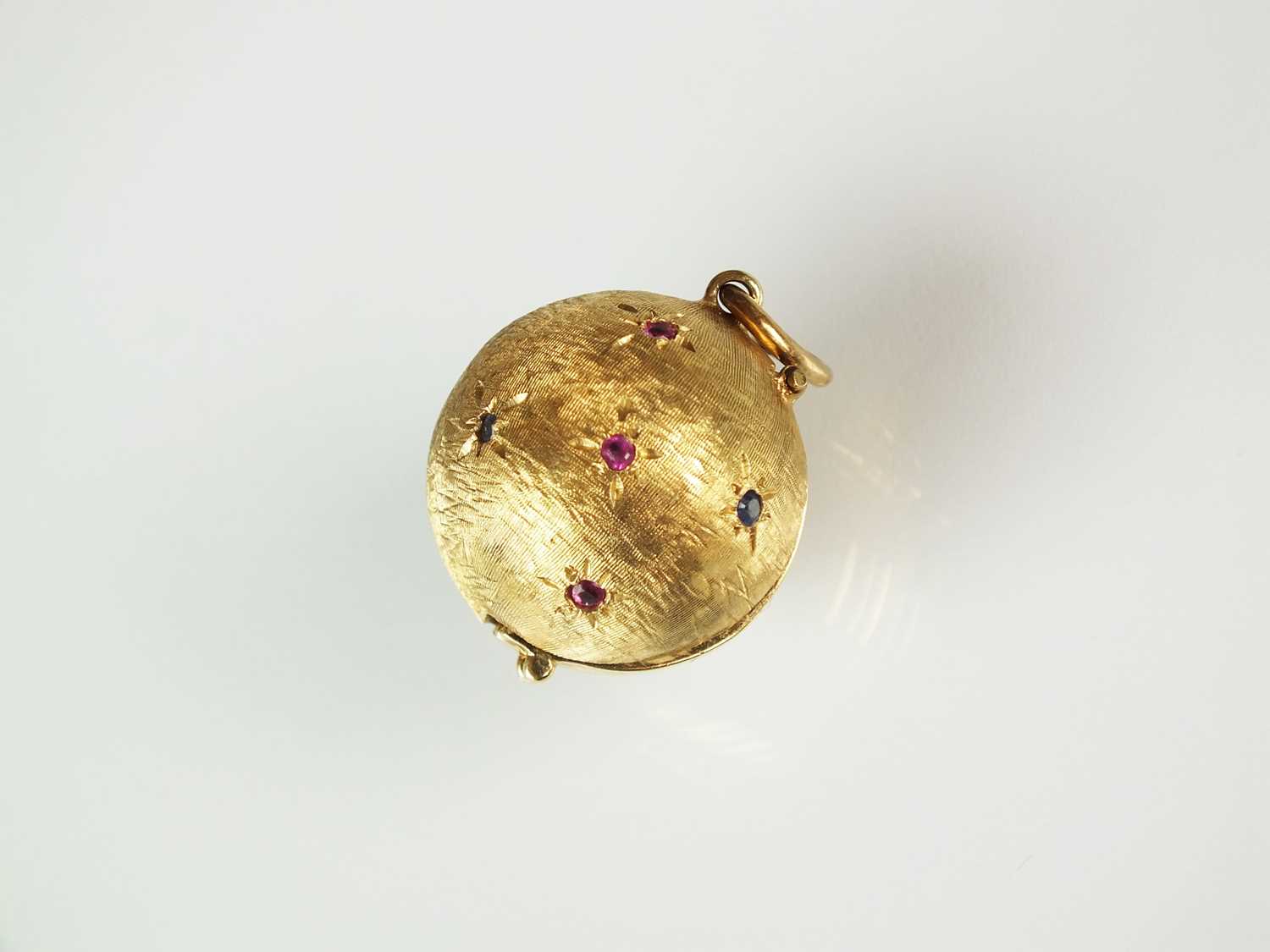 Lot 90 - A sapphire and ruby orb locket