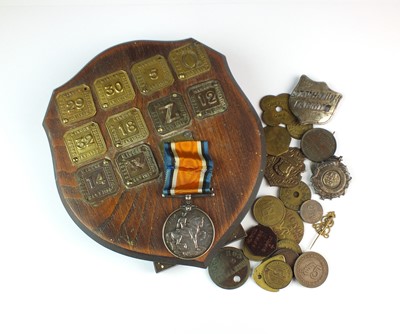 Lot 223 - A small collection of brass tokens, fobs and badges