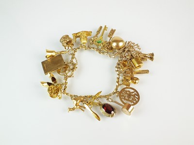 Lot 60 - A yellow metal charm bracelet with attached charms