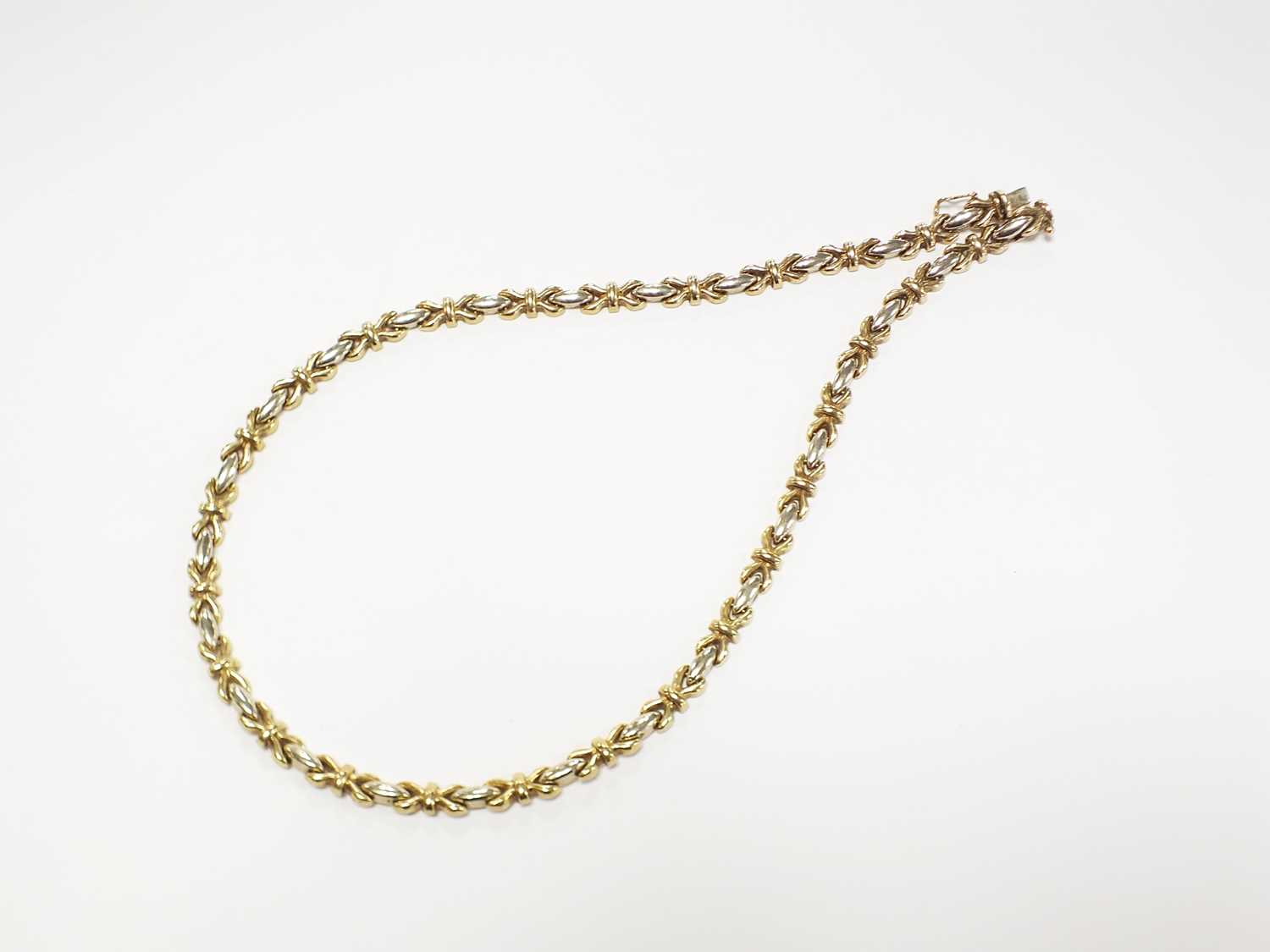 Lot 243 - A 9ct yellow and white gold cross and bar link chain necklace