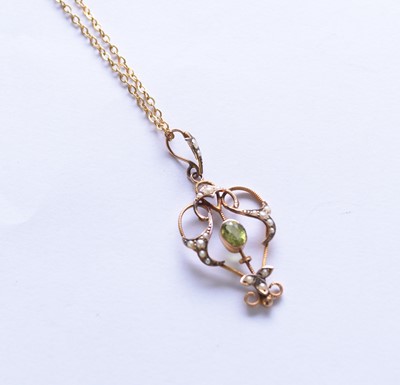 Lot 133 - An early 20th century peridot and seed pearl openwork pendant