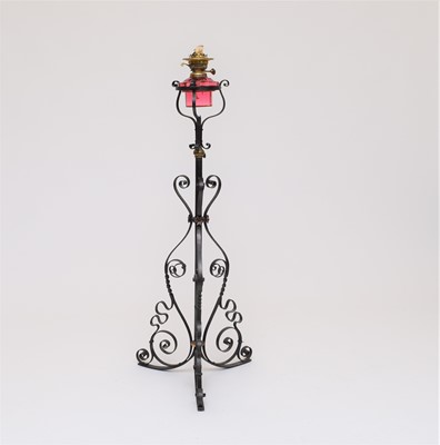 Lot 558 - A wrought iron and cranberry glass oil lamp standard