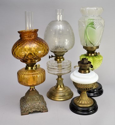 Lot 546 - Four various cast metal and glass oil lamps