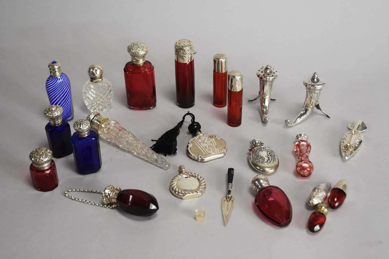 Lot 22 - A collection of silver and white metal mounted glass miniature scent bottles