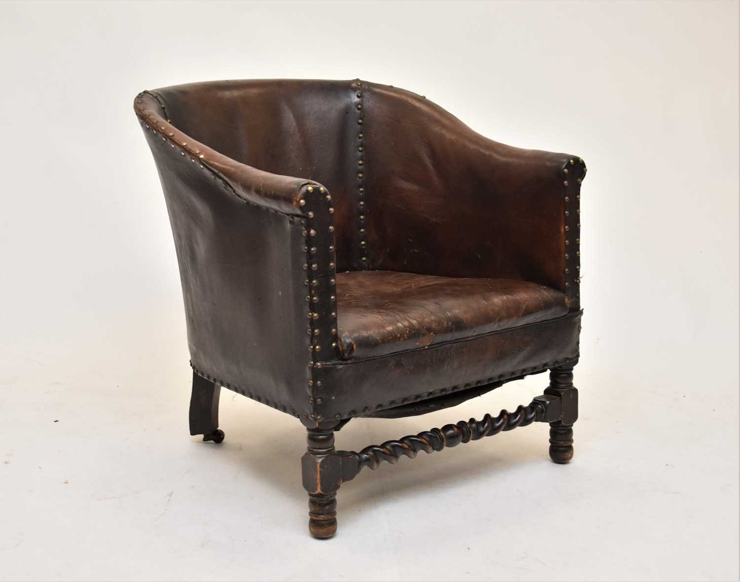 Lot 610 - An early 20th century hide covered tub chair