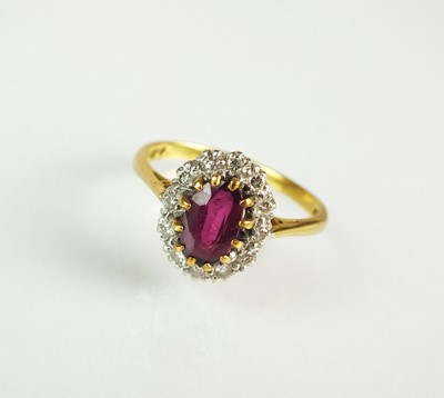 Lot 58 - An 18ct gold ruby and diamond oval cluster ring