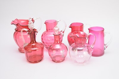 Lot 258 - Fifteen assorted cranberry glass jugs and...