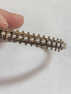 Lot 77 - A late 19th century untested pearl hinged bangle