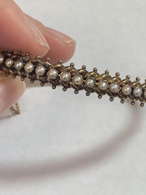 Lot 77 - A late 19th century untested pearl hinged bangle