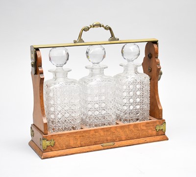 Lot 499 - A late Victorian oak and electroplated brass, three decanter tantalus