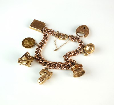 Lot 85 - A 9ct rose gold graduated curb link bracelet with attached charms