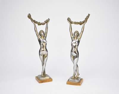 Lot 419 - A pair of Art Deco style chrome figures of naked ladies holding garlands aloft, 43cm