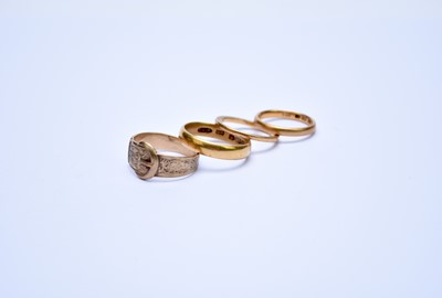 Lot 131 - Three 22ct bands and a 9ct gold buckle ring