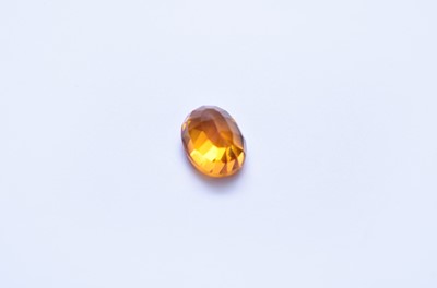 Lot 103 - An unmounted oval faceted orange sapphire