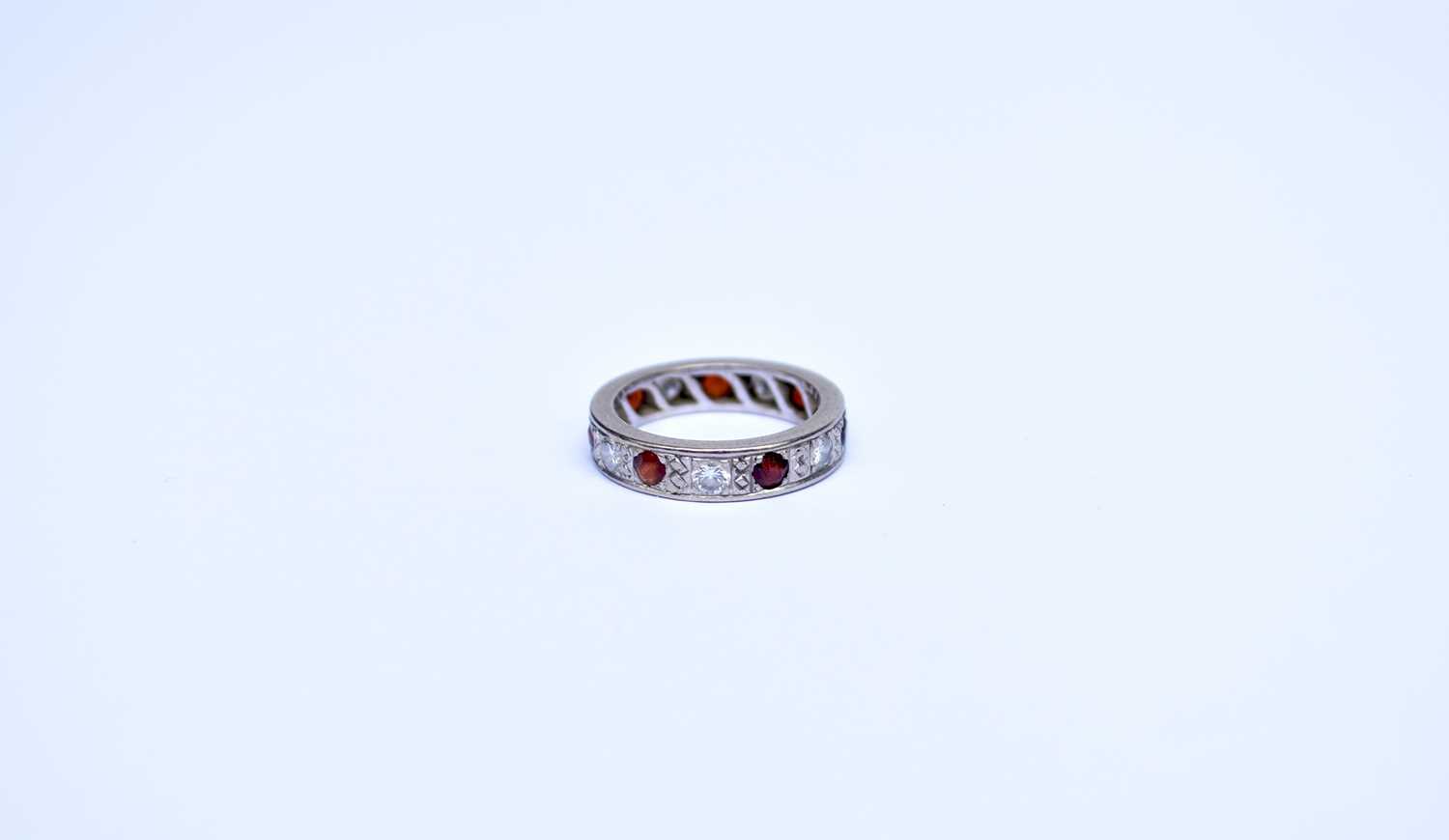 Lot 90 - A diamond and garnet eternity ring