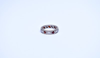 Lot 90 - A diamond and garnet eternity ring