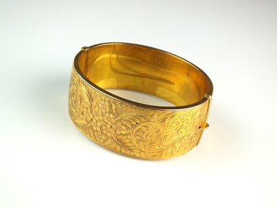 Lot 67 - A 9ct gold bright cut engraved bangle