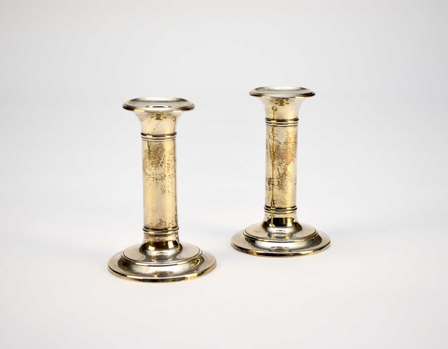 Lot 21 - A pair of Edwardian short silver candlesticks