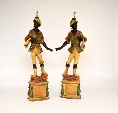 Lot 626 - A pair of reproduction painted wood blackamoor table lamps