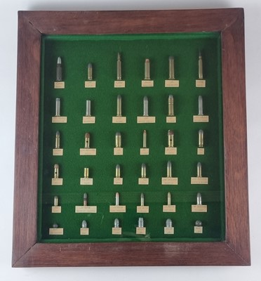 Lot 207 - Framed display of inert ammunition cartridges, with some bullets and balls.