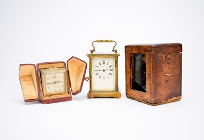 Lot 498 - A circa 1915 French brass carriage timepiece, cased, with another clockwork example, cased (4)