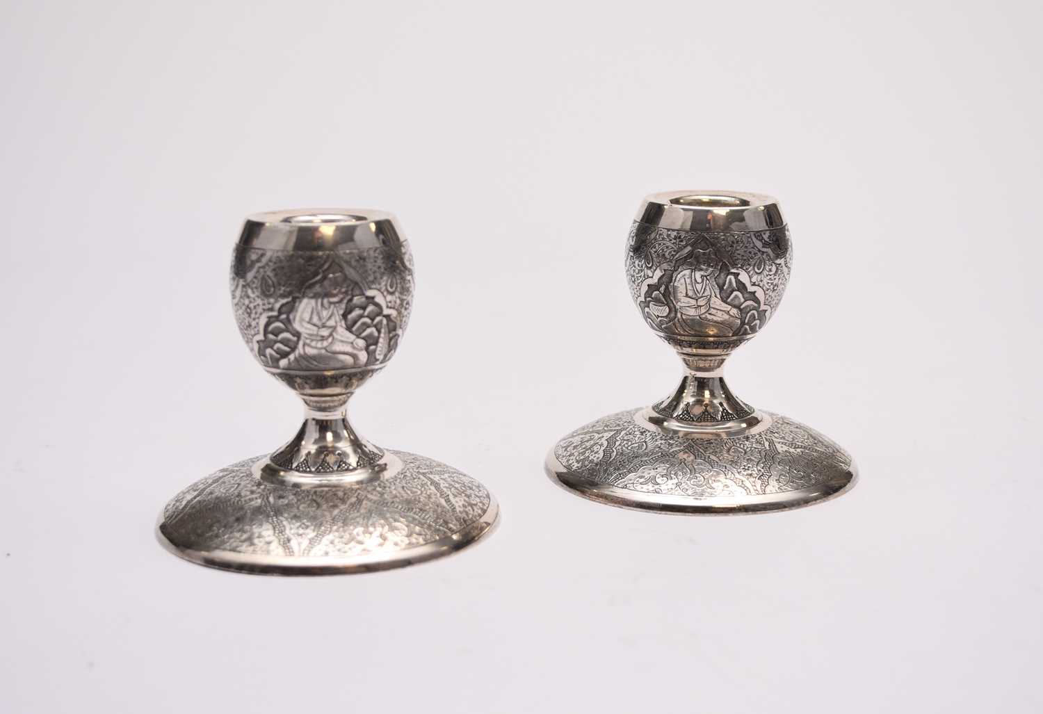 Lot 12 - A pair of white metal Middle Eastern candlesticks