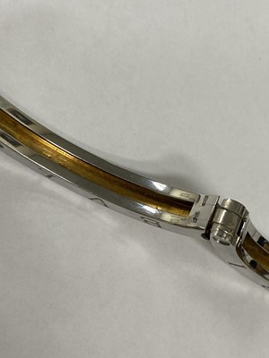 Lot 94 - A yellow metal and stainless steel Bvlgari hinged bangle