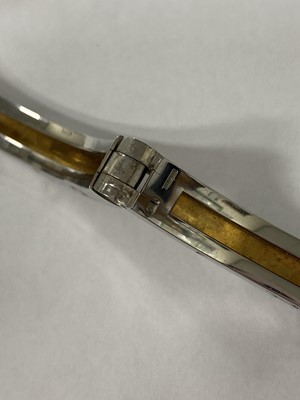 Lot 94 - A yellow metal and stainless steel Bvlgari hinged bangle