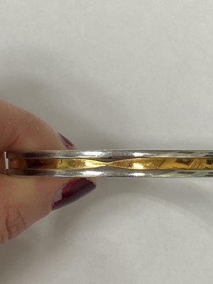 Lot 94 - A yellow metal and stainless steel Bvlgari hinged bangle