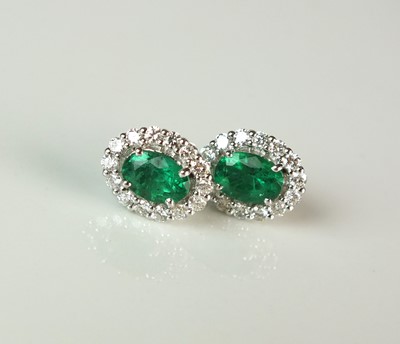 Lot 68 - A pair of emerald and diamond oval cluster earrings