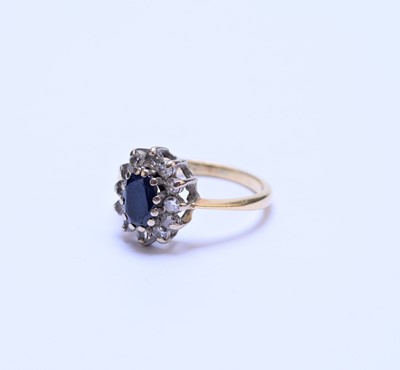 Lot 56 - A yellow metal oval sapphire and diamond cluster ring