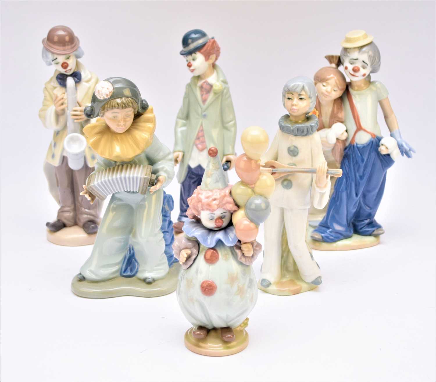 Lot 219 - Four Lladro clown figures and a Nao clown figure