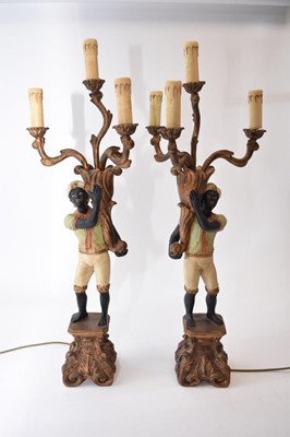 Lot 428 - A pair of reproduction painted wood blackamoor table lamps