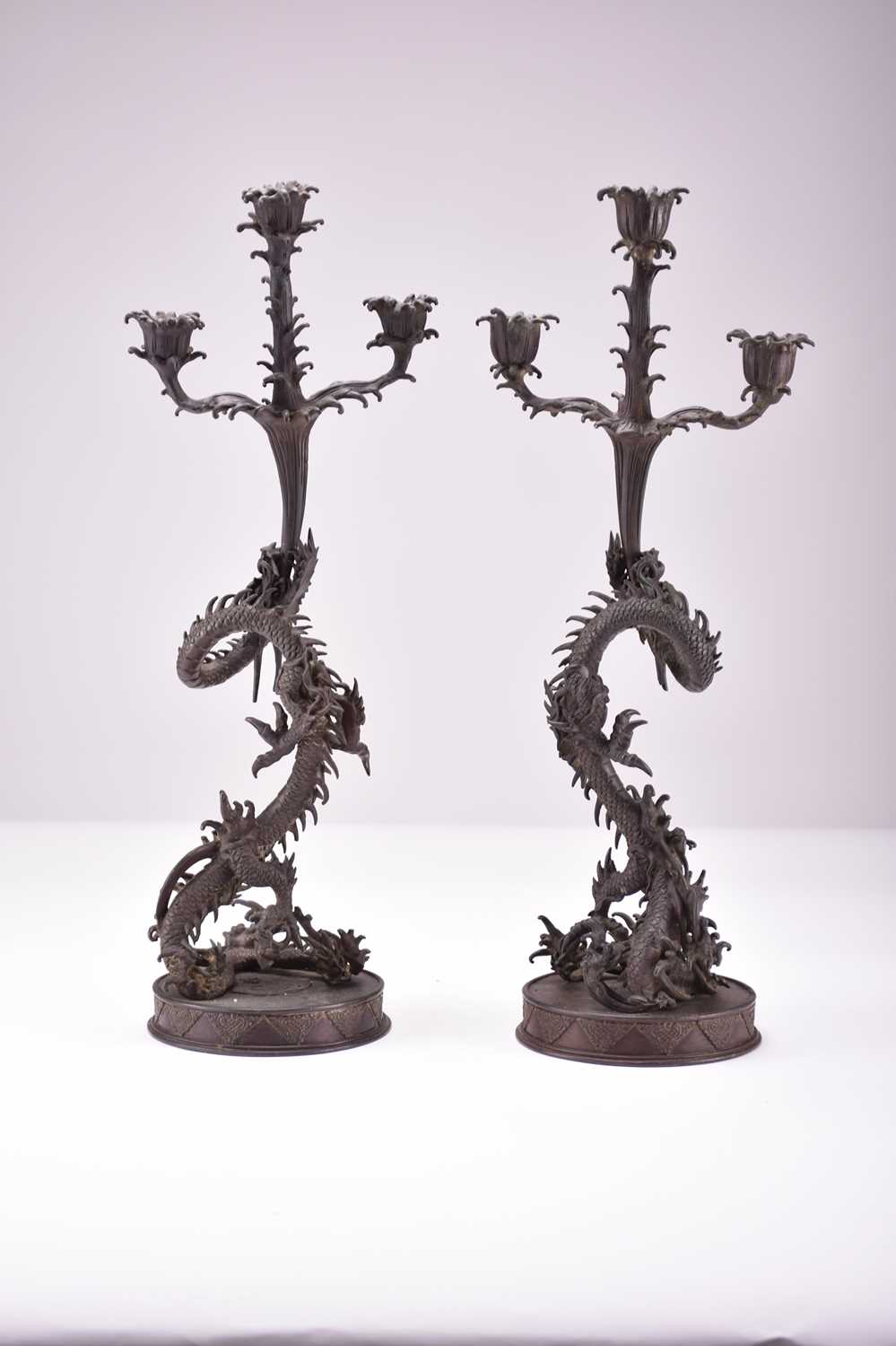 Lot 629 - A pair of Japanese bronze dragon candelabra, Meiji era