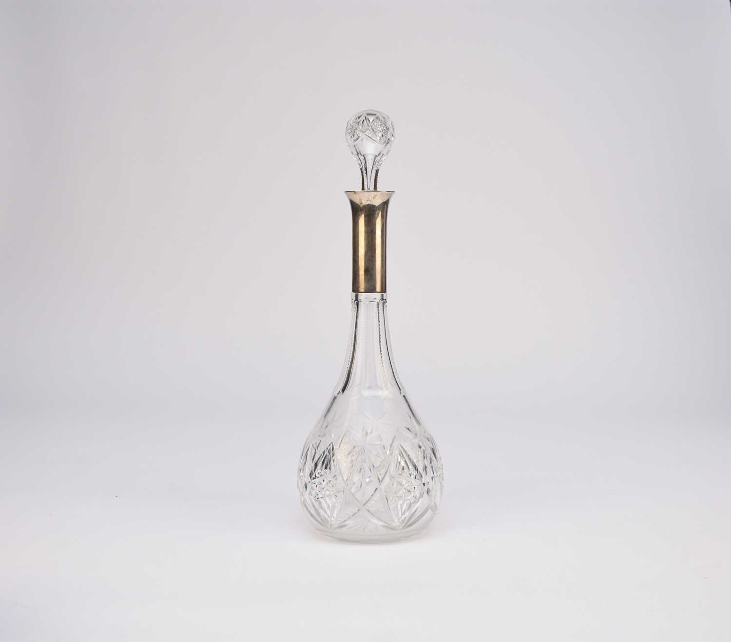 Lot 1 - A white metal mounted cut glass decanter