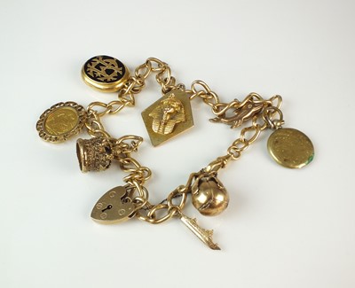 Lot 82 - An 18ct gold curb link chain with attached charms