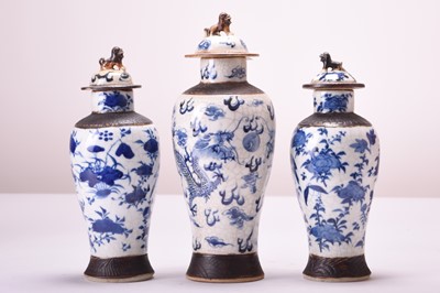 Lot 41 - A pair of Chinese blue and white crackle-glazed vases and covers and another similar