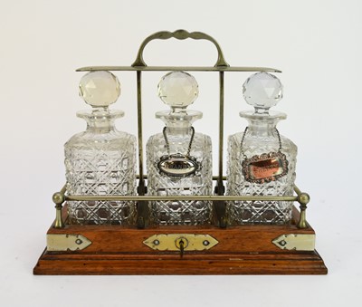 Lot 510 - An oak three-decanter tantalus