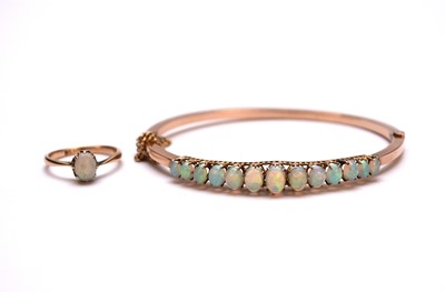 Lot 195 - An early 20th century opal set hinged bangle and an opal ring