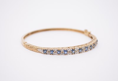 Lot 320 - A 9ct gold untested sapphire and diamond hinged bangle