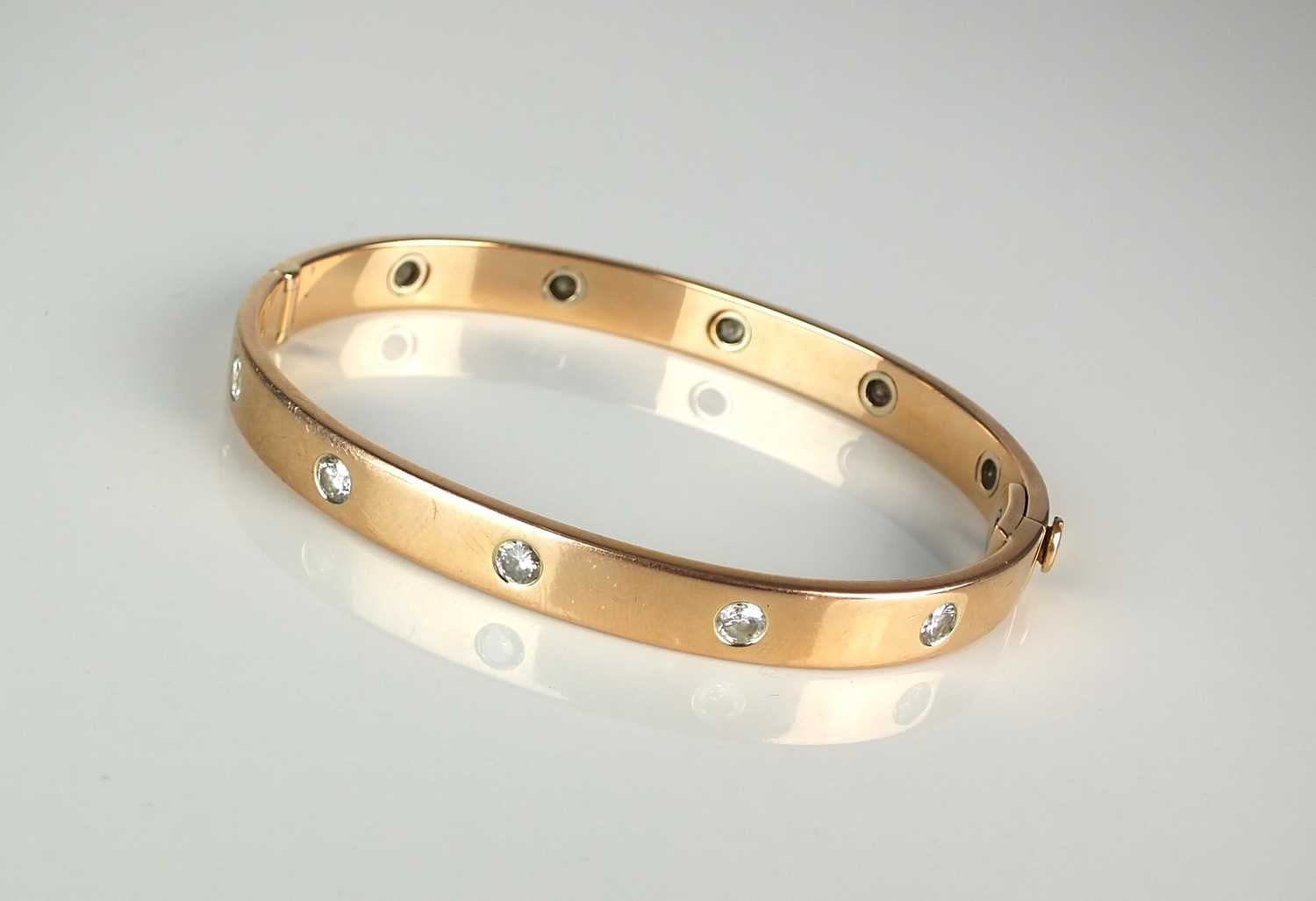 Lot 32 - A diamond set hinged bangle