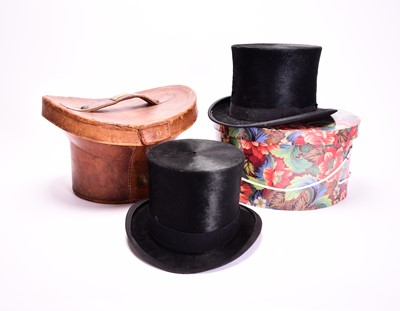 Lot 429 - Two black silk top hats, one in leather case