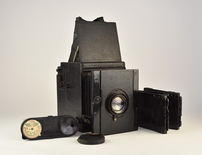 Lot 603 - A half plate camera with wood tripod, developing tank and dark plates