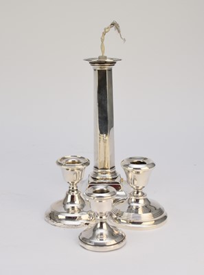 Lot 82 - A silver mounted lamp base and three candlesticks