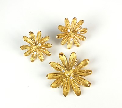 Lot 69 - A diamond set stylised flower brooch / pendant with matching earrings