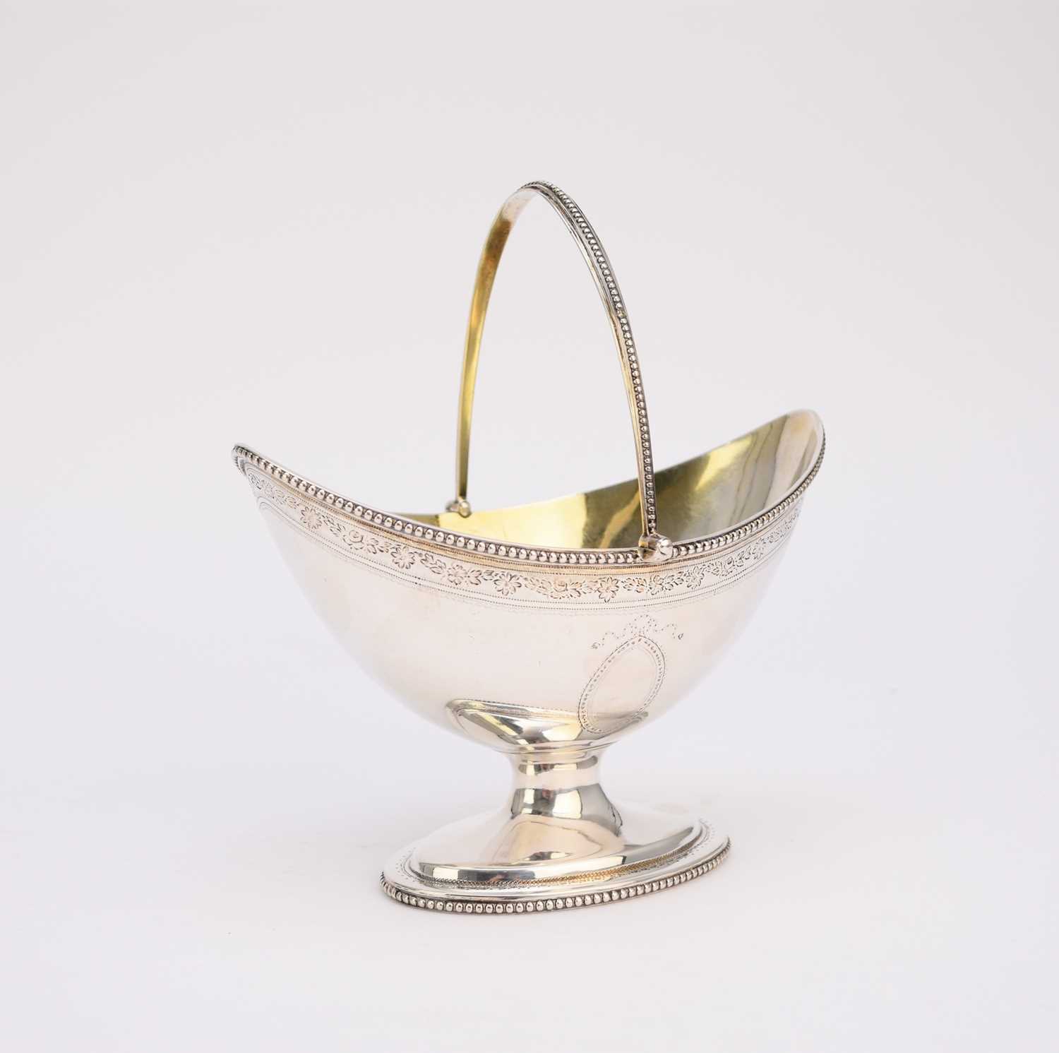 Lot 64 - A George III silver swing handled sugar basket