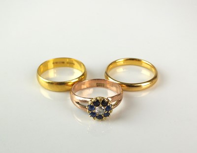 Lot 146 - Two 22ct gold wedding bands and a diamond and sapphire cluster ring