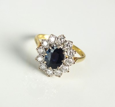 Lot 24 - An 18ct gold sapphire and diamond oval cluster ring